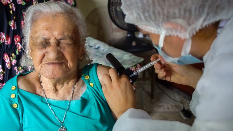 Joana de Freitas Leal, de 98 anos, foi a primeira idosa do município de Benevides à receber a vacina contra a covid-19. <div class='credito_fotos'>Foto: Divulgação &nbsp;&nbsp;|&nbsp;&nbsp; <a href='/midias/2021/originais/7214_f0ffaa8c-583d-83dd-d3c3-ce3ebde3fe36.jpg' download><i class='fa-solid fa-download'></i> Download</a></div>
